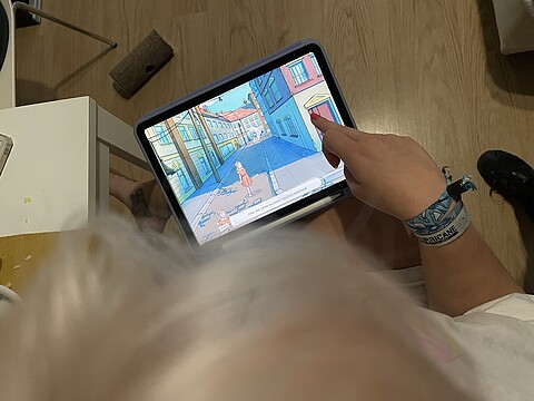 Bild eines Tablets von oben, das eine Schülerin auf dem Schoß hält